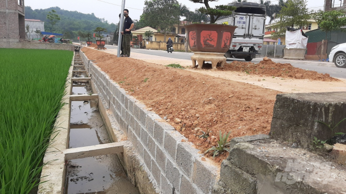 Công ty TNHH An Khánh Bắc Thái đã xây kè lên thành mương rồi cạp đất thêm vào để che đi những vết khe hở hàm ếch trên vỉa hè. Ảnh chụp ngày 15/4. Ảnh: Toán Nguyễn.