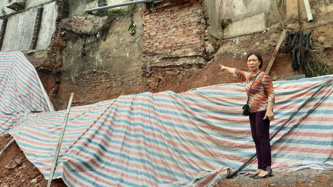 Bà Nguyễn Thị Thanh Nga chỉ việc doanh nghiệp đào cả vào móng nhà và sát mét tường bể phốt. Ảnh: Toán Nguyễn.