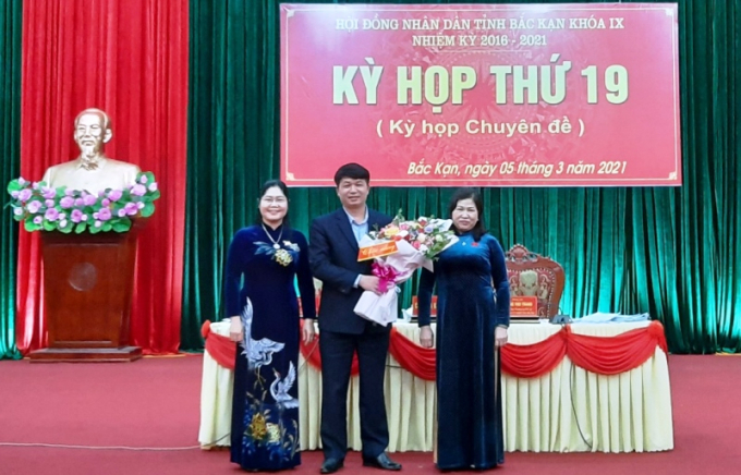 Ông Nông Quang Nhất nhận hoa chúc mừng của Chủ tịch HĐND tỉnh Phương Thị Thanh (bên phải) và Phó Chủ tịch Thường trực HĐND tỉnh Hoàng Thu Trang.