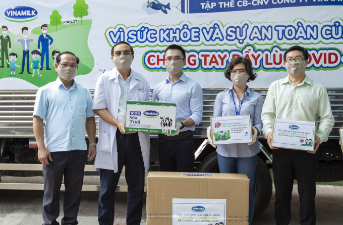 Anh Nguyễn Quang Thái, Giám đốc Phát triển Hoạt động Cộng đồng Vinamilk (đứng giữa) đại diện công ty trao tặng sữa cho các trẻ em có hoàn cảnh khó khăn cần giúp đỡ trong dịch Covid-19 vừa qua. Ảnh: Xuân Hương.
