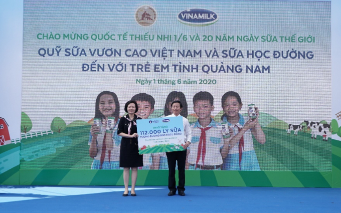 Đại diện Vinamilk trao tặng bảng tượng trưng 112.000 ly sữa từ Quỹ sữa Vươn cao Việt Nam cho trẻ em của tỉnh Quảng Nam. Ảnh: Xuân Hương.