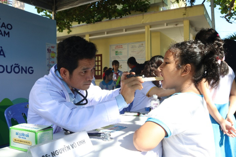 Các em học sinh được khám dinh dưỡng và kiểm tra sức khỏe bởi các bác sĩ của Trung tâm khám và tư vấn dinh dưỡng Vinamilk. Ảnh: Xuân Hương.