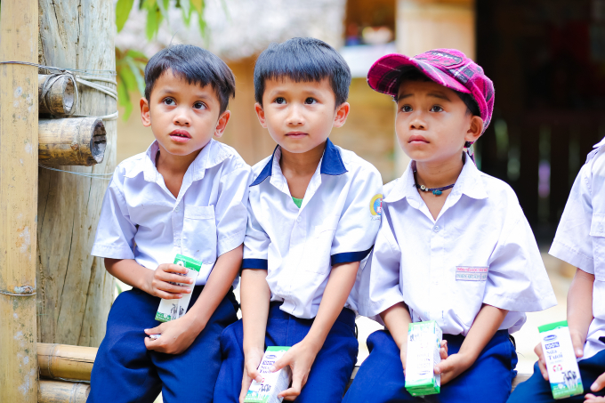 Các em học sinh huyện Đông Giang nhận những hộp sữa đầu tiên khi đến lớp theo chương trình Sữa học đường. Ảnh: Xuân Hương.