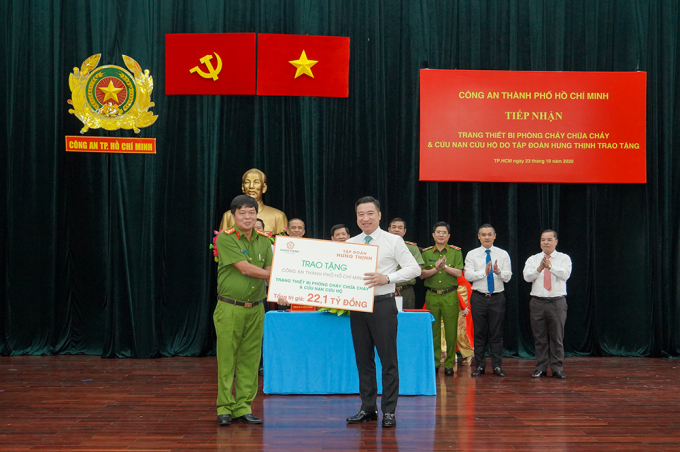 Ông Nguyễn Đình Trung (bìa phải) trao bảng tượng trưng trang thiết bị PCCC và cứu hộ cứu nạn trị giá 22,1 tỷ đồng cho Đại tá Nguyễn Thanh Hưởng. Ảnh: Trang Nguyễn.