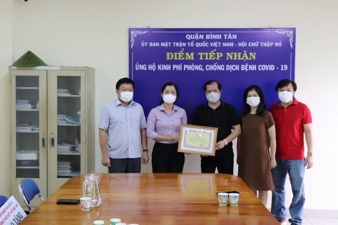 Ông Lê Văn Thinh, Bí thư quận Bình Tân (bìa trái) và bà Lê Thị Ngọc Dung, Phó Chủ tịch UBND quận Bình Tân trao giấy khen cho VIPA vì những đóng góp cho công tác phòng chống dịch. Ảnh: Đỗ Hưng.