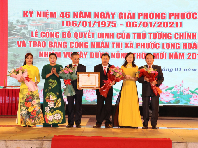 Thừa ủy quyền của Thủ tướng Chính phủ, lãnh đạo tỉnh Bình Phước trao quyết định công nhận TX. Phước Long hoàn thành Chương trình xây dựng NTM. Ảnh: CTV.