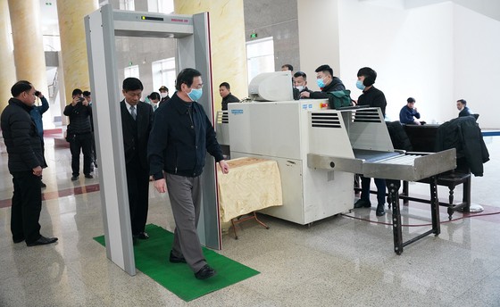 Bị cáo Vũ Huy Hoàng thực hiện kiểm tra an ninh trước khi vào phòng xử.