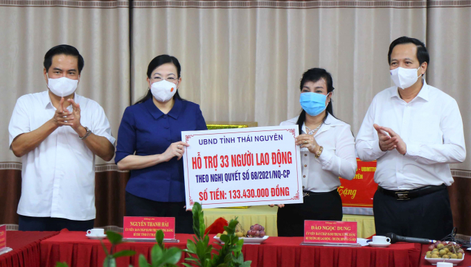Bộ trưởng Đào Ngọc Dung (Bìa phải) và Bí thư Tỉnh ủy Nguyễn Thanh Hải (Thứ hai từ trái qua) trao tiền hỗ trợ cho người lao động. Ảnh: TTTT Bộ LĐ-TBXH.