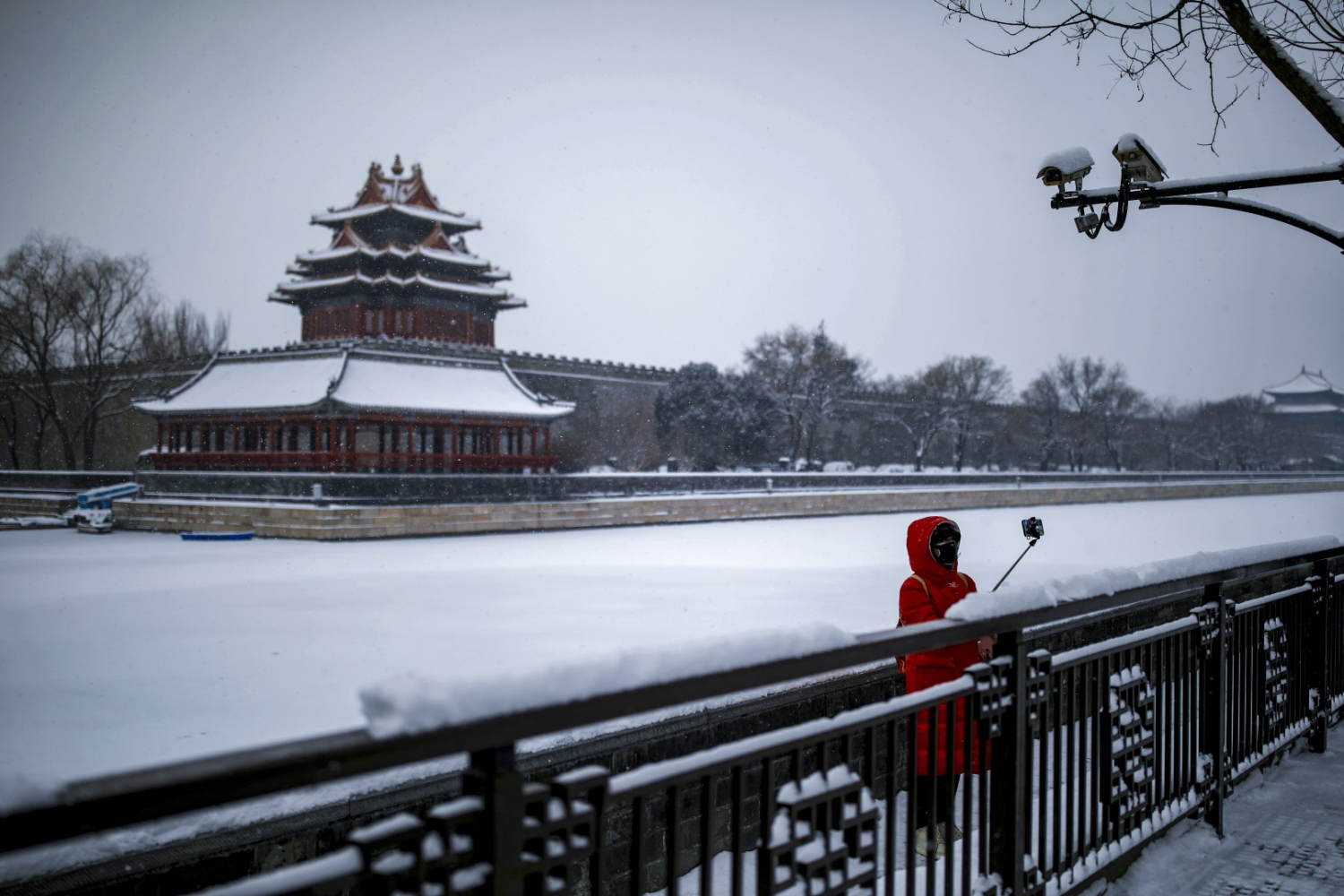 Nữ du khách đeo khẩu trang chụp ảnh trước Tử Cấm Thành. Một nhân viên an ninh của công viên Cảnh Sơn bên cạnh Tử Cấm Thành ở Bắc Kinh cho biết lượng khách giảm xuống còn chưa đến 1/3 so với trước đây.