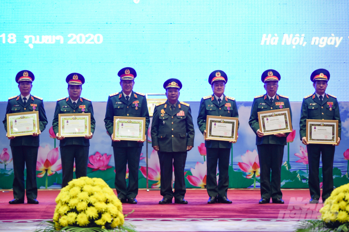 Bộ trưởng Bộ Quốc phòng Lào trao huân chương tặng các Thứ trưởng Quốc phòng Việt Nam. Ảnh: Tùng Đinh.