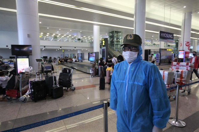 Nhân viên an ninh mặc đồ bảo và đeo kính, khẩu trang suốt 8 giờ làm việc tại sân bay Nội Bài. Ảnh: TPO.