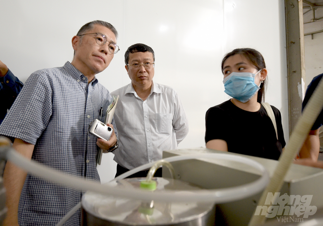 Ông Takayama (trái) và ông Hoàng Trung theo dõi quá trình hoạt động của hệ thống buồng khử trùng bằng Methyl Bromide. Ảnh: Tùng Đinh.