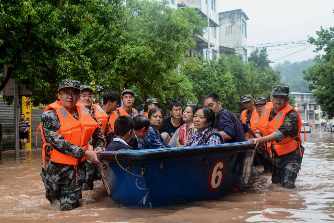 Lực lượng cứu hộ đưa người dân ra khỏi vùng ngập ở Trùng Khánh. Ảnh: NYT.