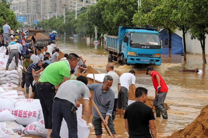 Người dân Trung Quốc đang làm bao cát để ngăn nước lũ tấn công vào khu dân cư.