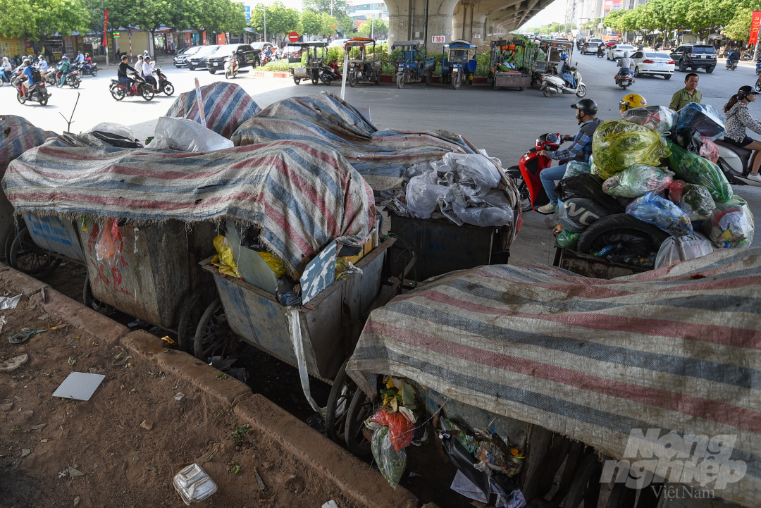 Một số điểm tập kết rác dọc đường Nguyễn Xiển không thể giải phóng phải phủ bạt che tạm nhưng vẫn bốc mùi hôi thối do thời tiết nóng bức kéo dài.