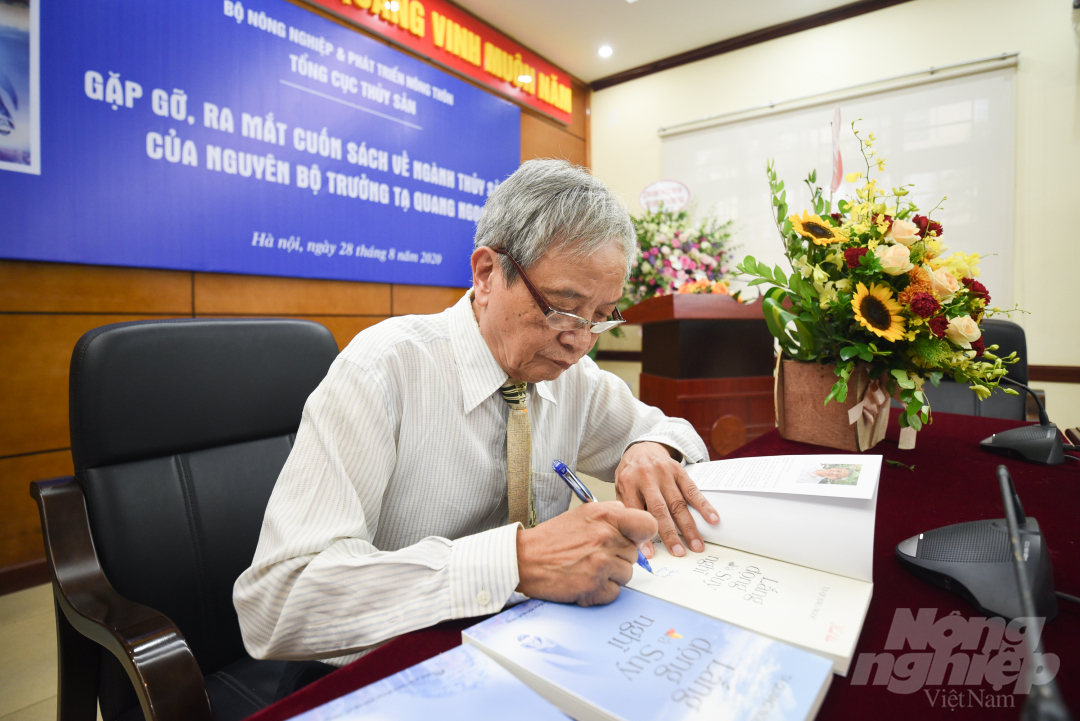 Nguyên Bộ trưởng Bộ Thủy sản Tạ Quang Ngọc ký tặng một số bạn đọc trong buổi ra mắt sách. Ảnh: Tùng Đinh.