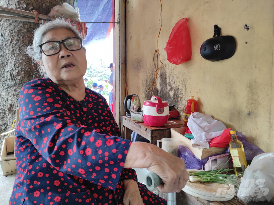 Mẹ liệt sỹ Đinh Thị Xoan (80 tuổi) nấu ăn tạm bợ ngay tại nơi bán nước kiếm sống đầu ngõ 217 Trần Phú, Hà Đông. Ảnh: Tùng Đinh.