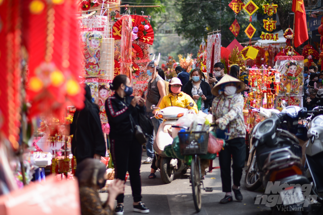 Tuy vắng hơn bình thường, nhưng để đảm bảo an toàn phòng chống dịch, người bán, người mua, người tham quan ở chợ hoa truyền thống của Hà Nội thực hiện rất tốt quy định đeo khẩu trang.