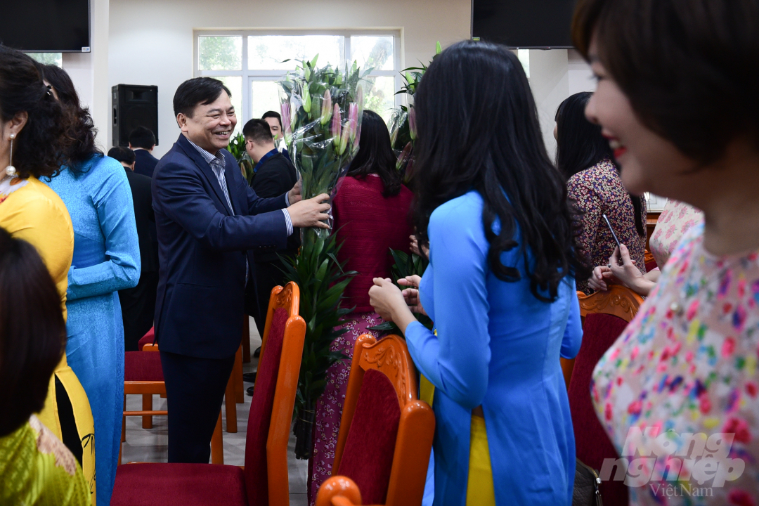 Thứ trưởng Nguyễn Hoàng Hiệp tặng hoa các nữ cán bộ trong lễ kỷ niệm ngày 8/3. Ảnh: Tùng Đinh.