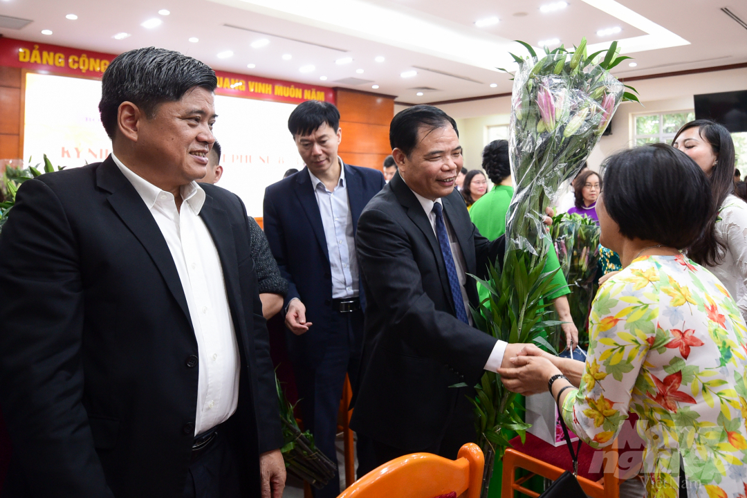 Bộ trưởng Nguyễn Xuân Cường, Thứ trưởng Trần Thanh Nam tặng hoa và quà cho các nữ đại biểu. Ảnh: Tùng Đinh.