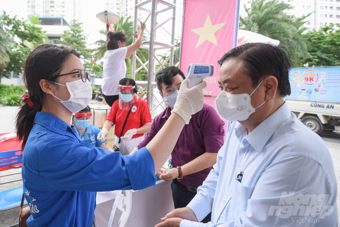 Bộ trưởng Bộ NN-PTNT Lê Minh Hoan có mặt tại điểm bầu cử rất sớm, ông được các bộ phận của ban tổ chức kiểm tra thân nhiệt trước khi vào điểm bỏ phiếu.