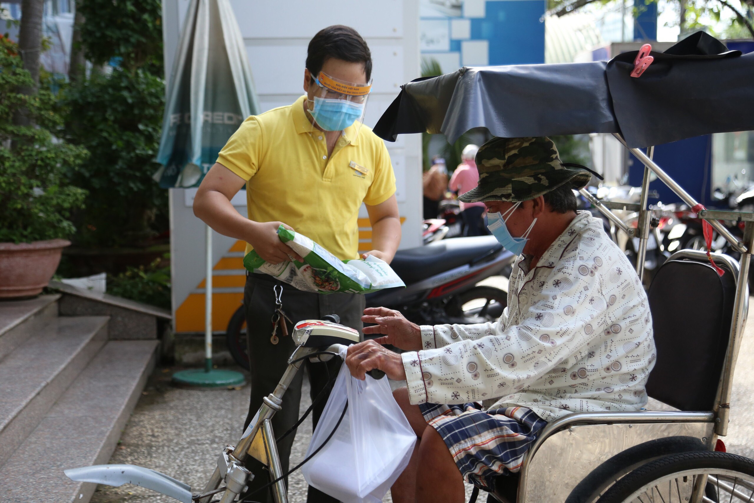 Nhân viên Bưu điện Việt Nam trao gạo cho người dân gặp khó khăn do Covid-19.