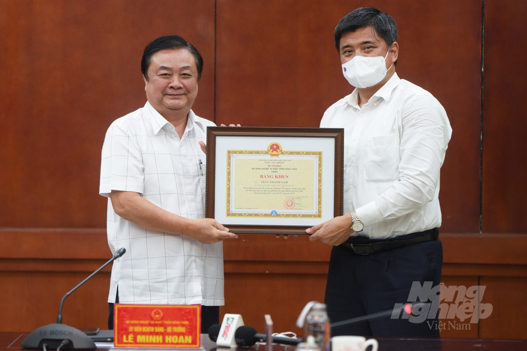 Bộ trưởng Lê Minh Hoan tặng bằng khen cho Thứ trưởng Trần Thanh Nam. Ảnh: Tùng Đinh.