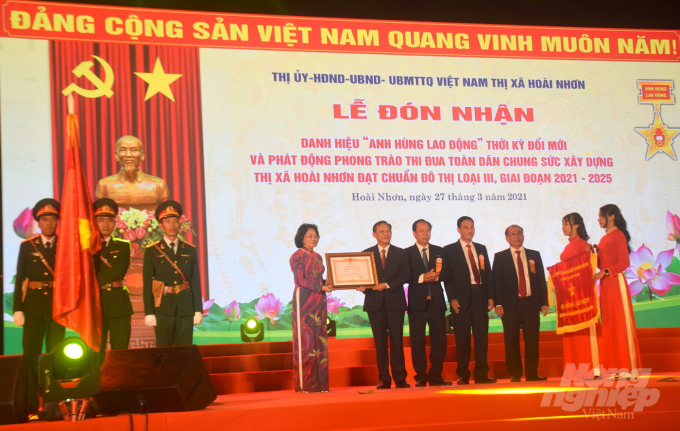 Phó Chủ tịch nước Đặng Thị Ngọc Thịnh trao danh hiệu Anh hùng lao động thời kỳ đổi mới cho TX Hoài Nhơn. Ảnh: Vũ Đình Thung.