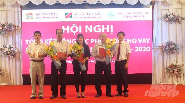 Ông Nguyễn Xuân Hùng, Giám đốc Agribank Bình Định (ngoài cùng bìa phải) khen thưởng các cá nhân, tập thể có đóng góp tích cực trong công tác thực hiện cho vay vốn qua tổ.