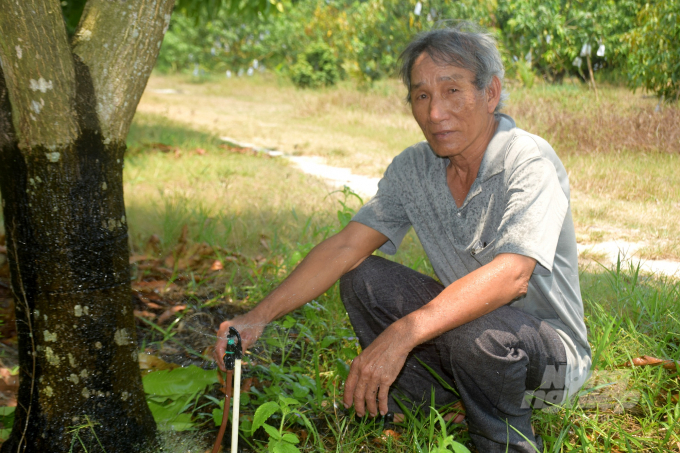Nông dân Nguyễn Ngọc chia sẻ lợi ích khi áp dụng chảo bốc thoát hơi nước (mini-pan) tưới cho 800 gốc xoài của mình. Ảnh: Vũ Đình Thung.