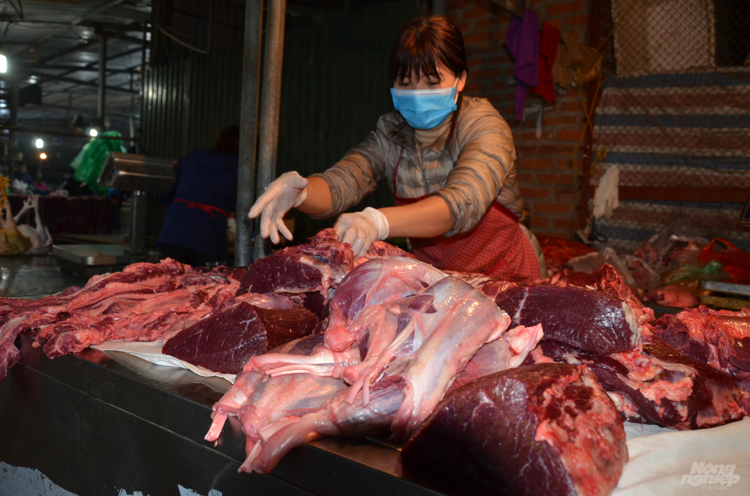 Giá mỗi kg bò ngon nhất hiện ở 250.000đ/kg.      Chủ hàng thịt lợn tranh thủ lúc rảnh ghi chép đơn hàng.