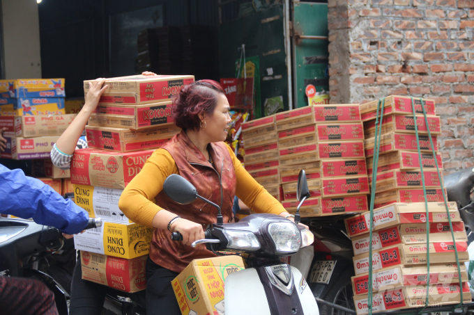 Một người phụ nữ đi mua mỳ tôm về tích trữ ở đường Vũ Tông Phan, Thanh Xuân.