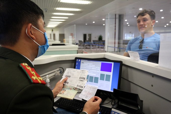 Công an cửa khẩu Nội Bài kiểm tra giấy tờ của khách nước ngoài khi nhập cảnh vào Việt Nam.Ảnh: Bá Đô/VnExpress.