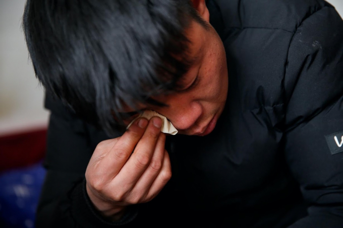 Dương Niên Liên rơi nước mắt khi kể về gia đình trong một bữa ăn mừng Năm mới cùng vợ ở Bắc Kinh. Ảnh: Reuters.