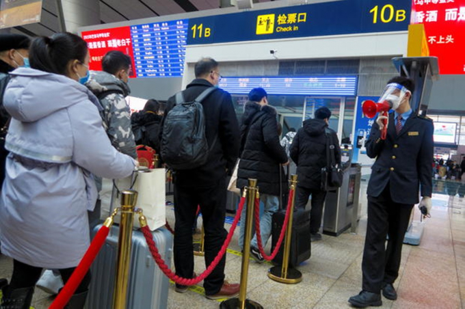 Hành khách chờ lên tàu tại nhà ga đường sắt Nam Bắc Kinh ngày 10/2. Ảnh: Reuters.