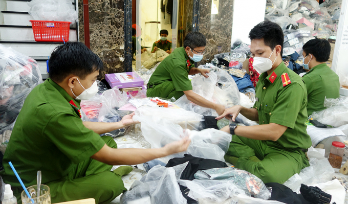 Lực lượng Công an kiểm đếm, tạm giữ số sản phẩm hàng hóa không nguồn gốc và  nhập lậu. Ảnh: Tiến Tầm. 