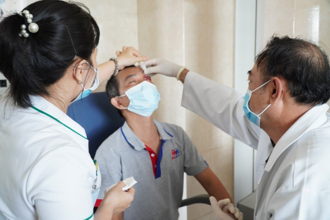  BS. CKI Trần Việt Hùng (Bệnh viện Mắt Sài Gòn Cần Thơ) đang xử lý vết thương cho bệnh nhân. Ảnh: Hoàng Vũ.