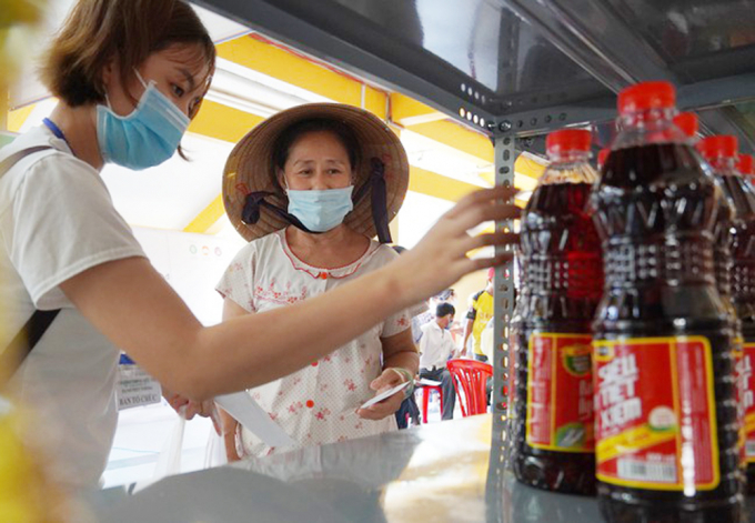 Người dân nghèo đến 'mua sắm' tại siêu thị được các nhân viên hỗ trợ nhiệt tình. Ảnh: MV.