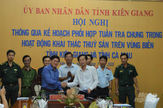 Chủ tịch UBND tỉnh Kiên Giang, Đỗ Thanh Bình (áo trắng) cùng Phó Chủ tịch UBND tỉnh Cà Mau, Lê Văn Sử trao văn bản và bắt tay cam kết phối hợp tuần tra chung trong hoạt động khai thác hải sản trên vùng biển của 2 tỉnh. Ảnh: Trung Chánh.