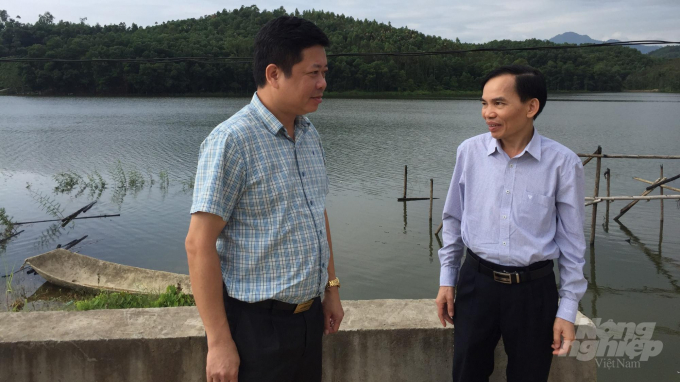 Ông Nguyễn Đăng Hà - Vụ trưởng Vụ An toàn đập, Tổng cục Thủy lợi (trái) trao đổi với ông Trần Quốc Bình - Phó Giám đốc Sở NN-PTNT Phú Thọ tại hồ Ban, huyện Cẩm Khê sáng 8/10. Ảnh: Minh Phúc.