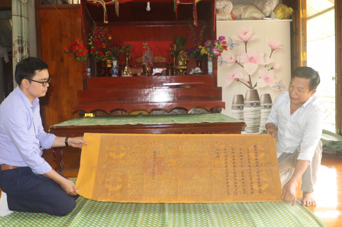 t2-1508_20210418_231.jpg Ông Phạm Gia Viễn (phải) cho xem sắc phong của vua Khải Định ban cho đình Làng Dọc. Ảnh: Thái Sinh.