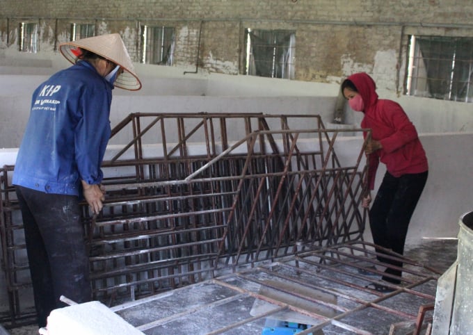 Bà Hoàng Thị Hương, thôn Cao Cương, xã Đông Quang bán bớt các khung sắt chia ô nuôi lợn, vì thời gian tới sẽ không đủ khả năng vào đàn. Ảnh: Trung Quân.