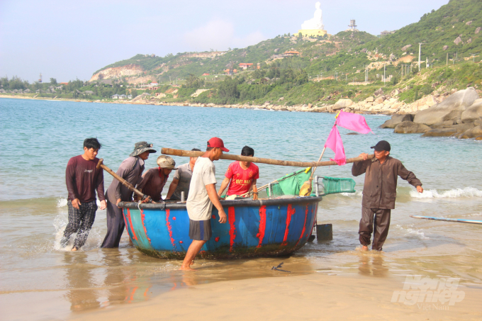 Sau chuyến đánh bắt, ngư dân phụ nhau khiêng những chiếc thuyền thúng về nơi tập kết ngư lưới cụ đợi đêm đến mở chuyến biển mới. Ảnh: Vũ Đình Thung.