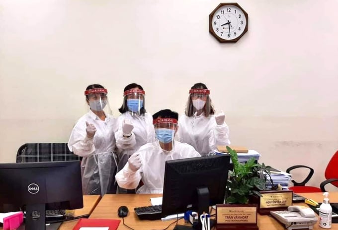 Tại một số 'điểm nóng' dịch bệnh Covid-19, cán bộ Agribank phải mặc đồ bảo hộ kín người để phục vụ khách hàng. Ảnh: NH.