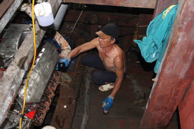 Tàu không ra khơi, các chủ tàu vẫn phải túc trực trông nom, bảo dưỡng động cơ, sẵn sàng vươn khơi khi thuận lợi và di chuyểnvào nơi tránh trú bão. Ảnh: Trung Quân.