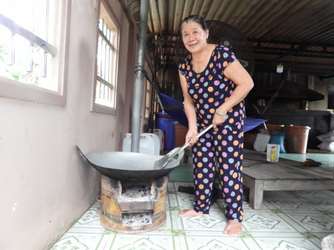 Bà Mỹ Vân chủ cơ sở sản xuất muối tôm Mỹ Vân tái hiện cảnh rang muối thủ công ngày xưa. Ảnh: Trần Trung.