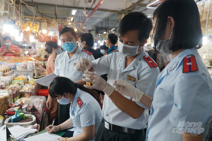 Test nhanh mẫu thực phẩm tại chợ. Ảnh: Nguyễn Thủy.