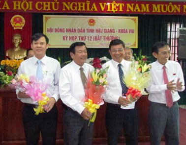 Ông Trương Cảnh Tuyên (bên trái) nhận hoa chúc mừng từ lãnh đạo tỉnh Hậu Giang 