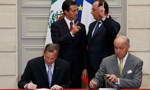 Tổng thống Pháp Francois Hollande (phía sau bên phải) trao đổi với Tổng thống Mexico Enrique Pena Nieto (phía sau bên trái) trong khi Bộ trưởng ngoại giao Pháp Laurent Fabius (bên phải) và người đồng cấp Mexico Jose Antonio Meade Kuribrena ký một tuyên bố chung về biến đổi khí hậu vào ngày 16/7. Ảnh: POOL / REUTERS
