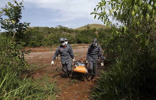 Những nhân viên cứu hỏa chuyển thi thể một nạn nhân bên bờ sông Rio Doce. Ảnh: Ricardo Moraes / Reuters